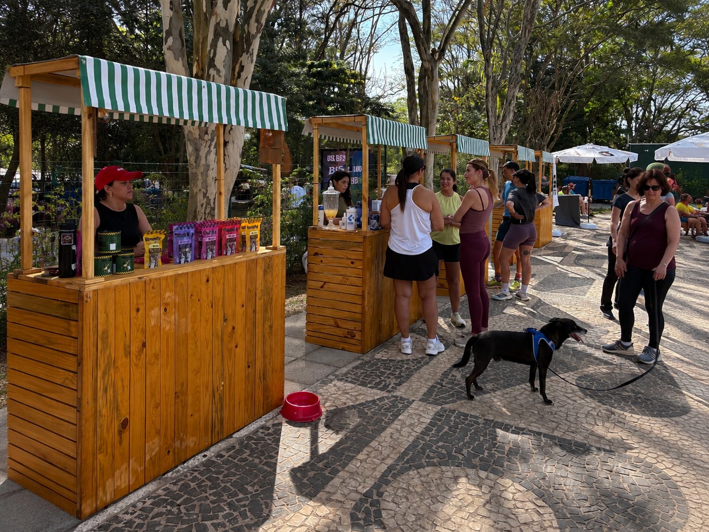 Barraca com produtos expostos e visitantes em volta durante a feira